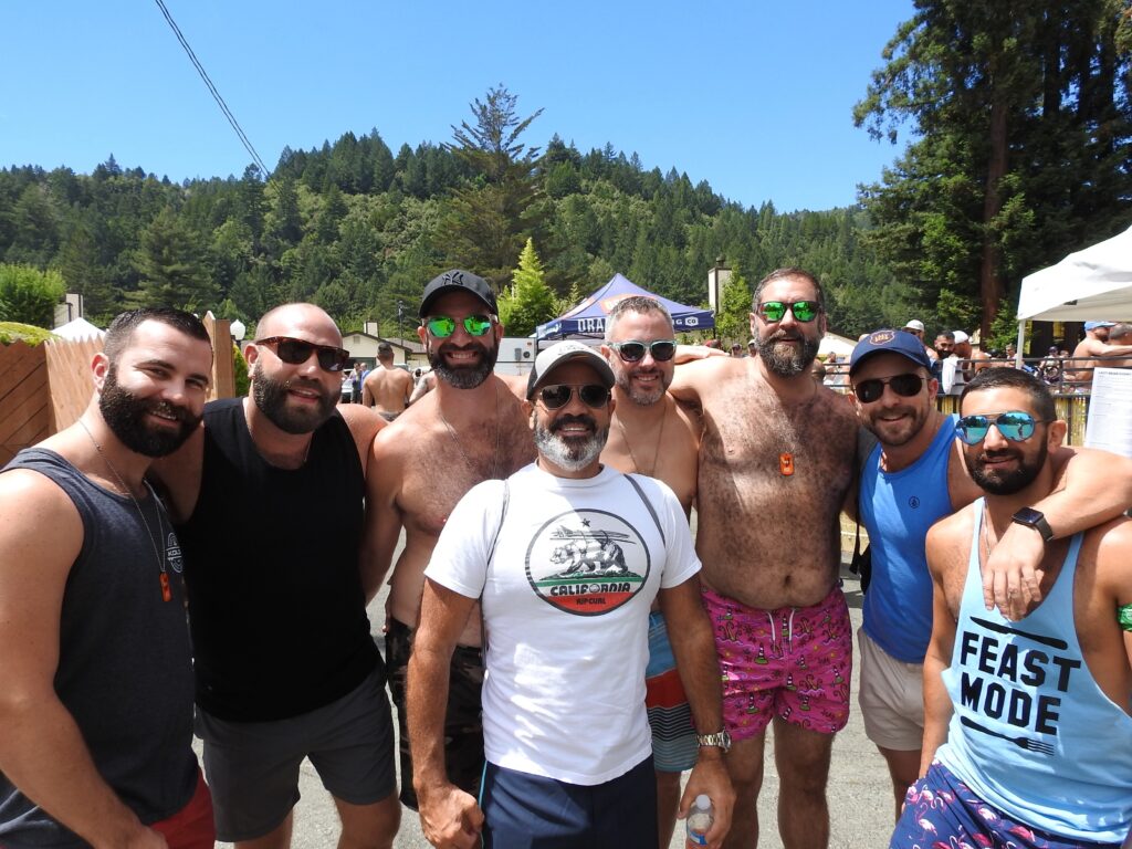 Friends gathering beneath the redwoods during Lazy Bear Week in Guerneville